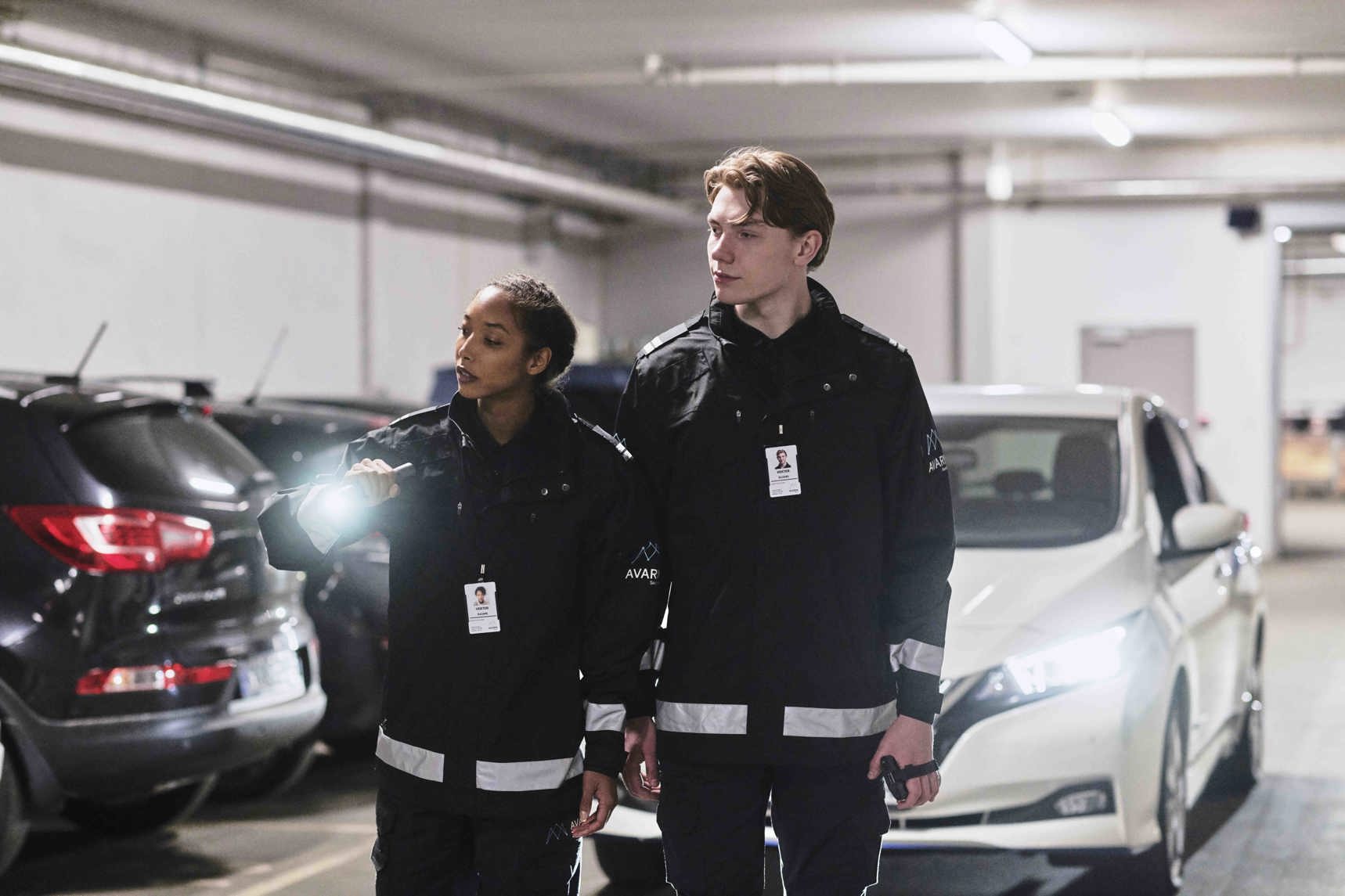 To vektere som sjekker en parkeringsgarasje