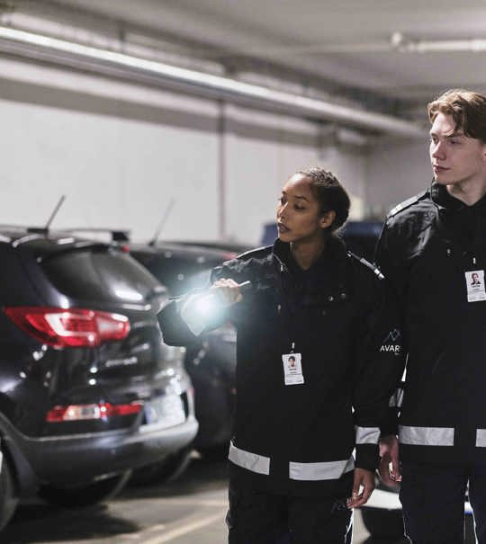 To vektere som sjekker en parkeringsgarasje