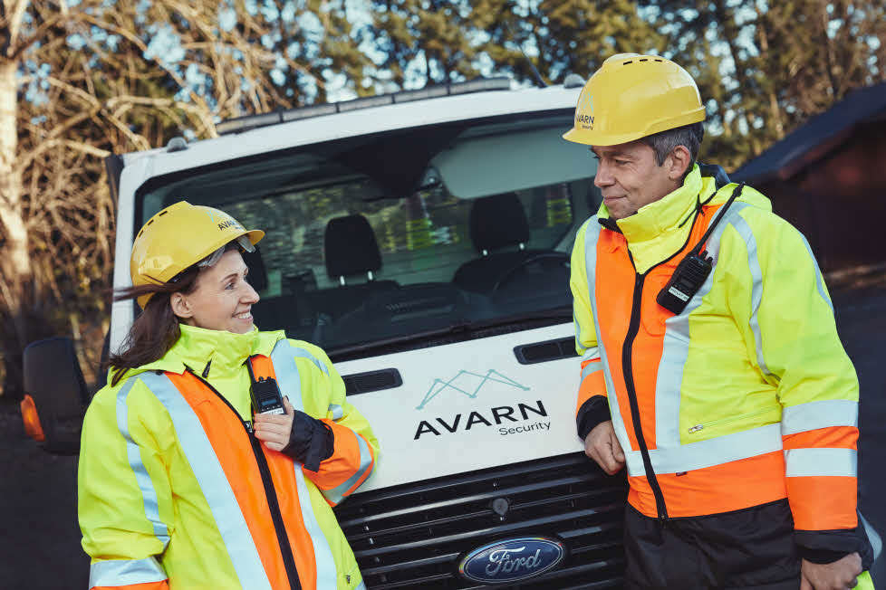 To trafikkdirigenter som står foran en Avarn bil